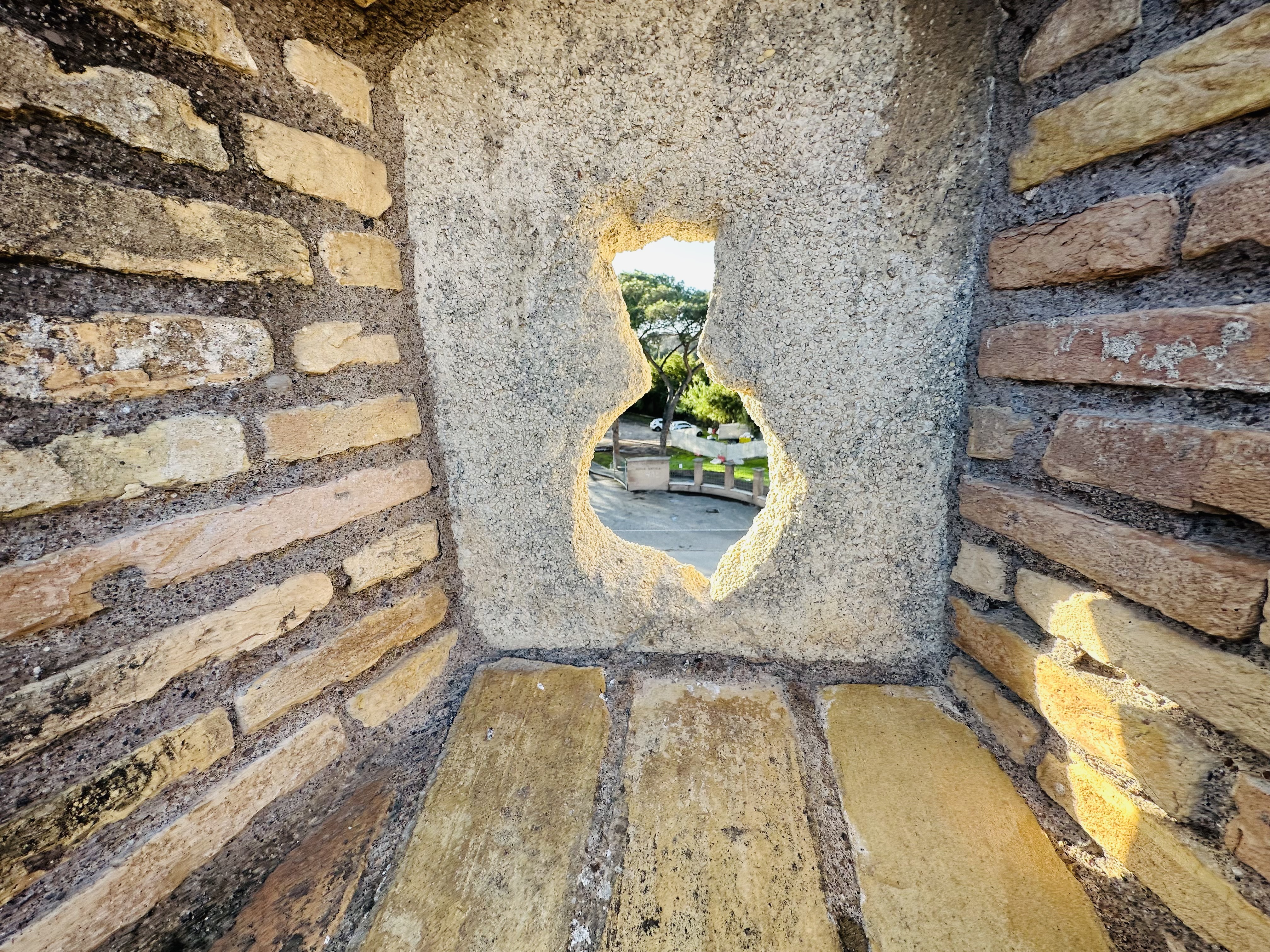 砦の壁にあいた射撃孔の内部から外を覗く様子